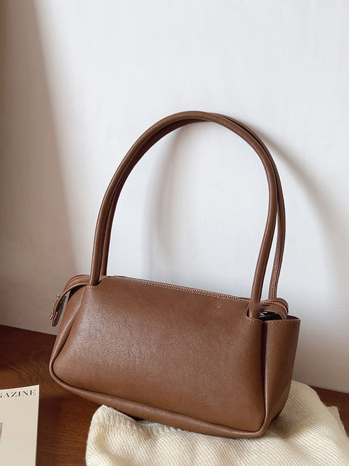 Brown rectangular shoulder bag resting on a chair