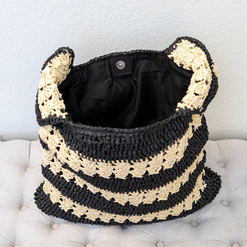 Open black and beige striped tote showing its dark lining and inside pocket